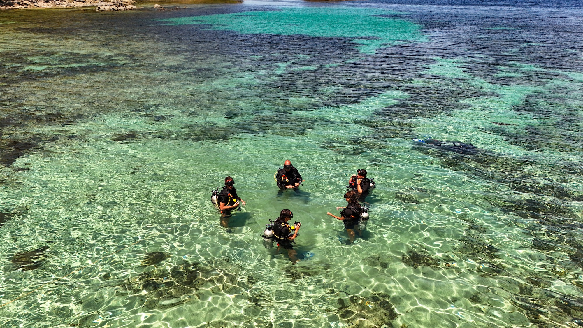 Student diver and instructor during first underwater skills in clear water